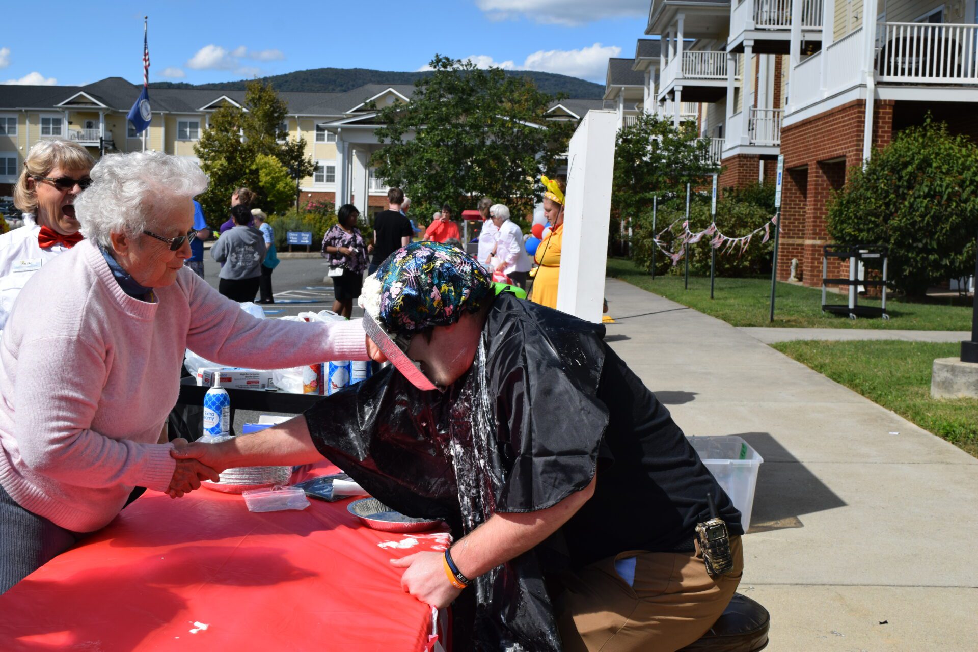 DSC_0020 a woman is handing a woman a hat