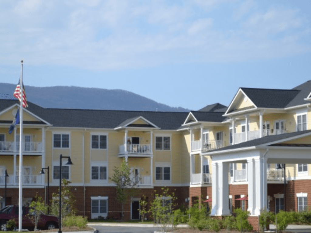 a large building with a flag and mountains in the background a large building with a flag and mountains in the background